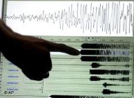 Symbolic image of scientist looking at seismograph 